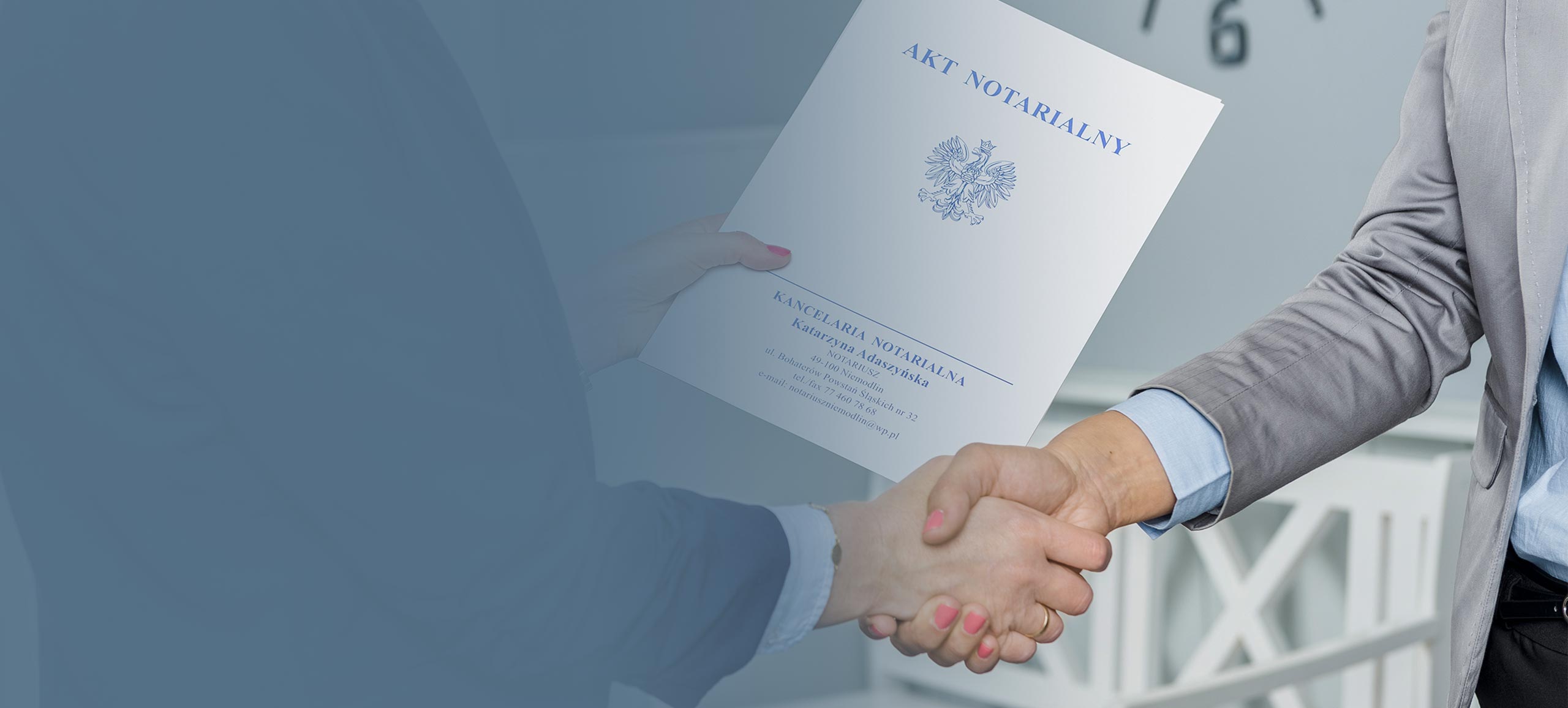 Zdjęcie notariusz Katarzyny Adaszyńskiej przekazującej akt notarialny swojej klientce.